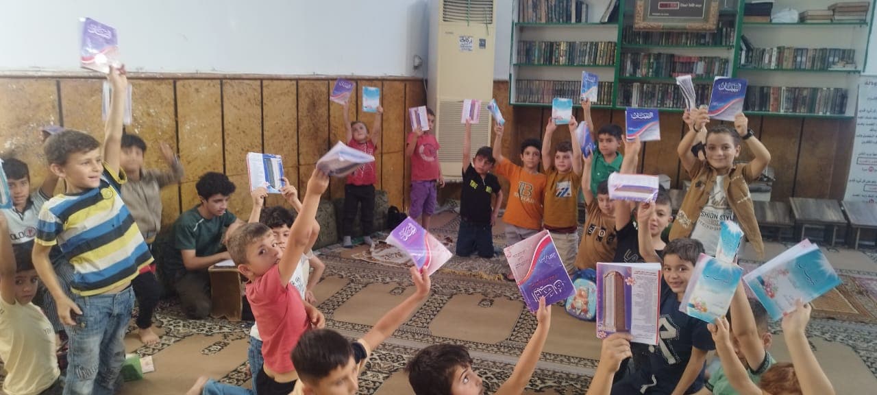طلاب معهد التبيان يرفعون كتبهم داخل الحلقة